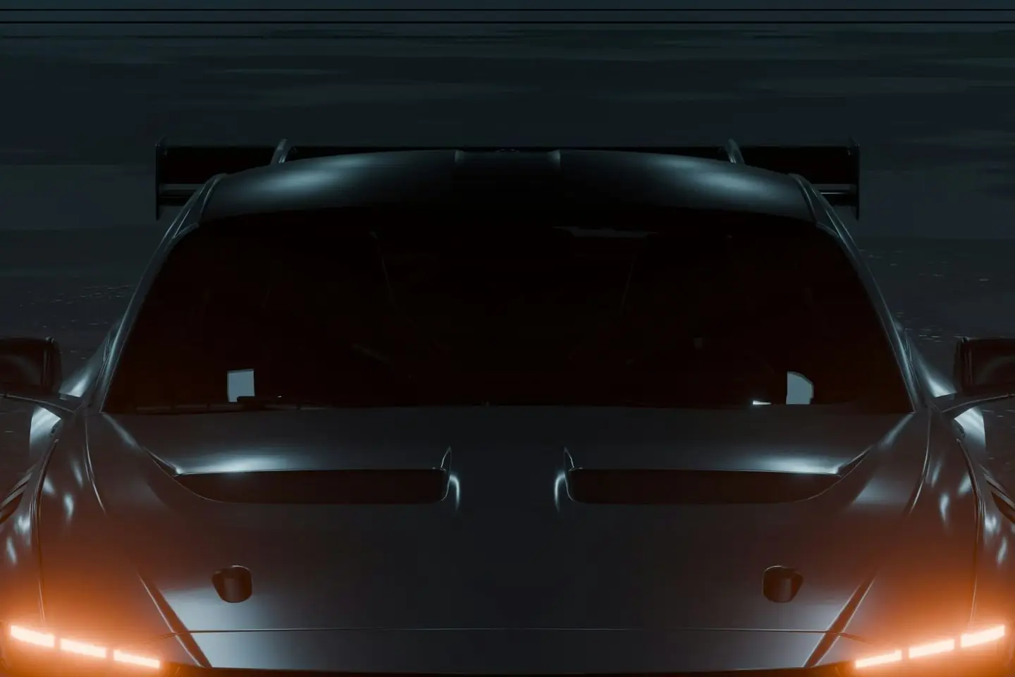 The hood, vents and windscreen of a dark grey sports car in low light, with its amber headlights along the lower edge